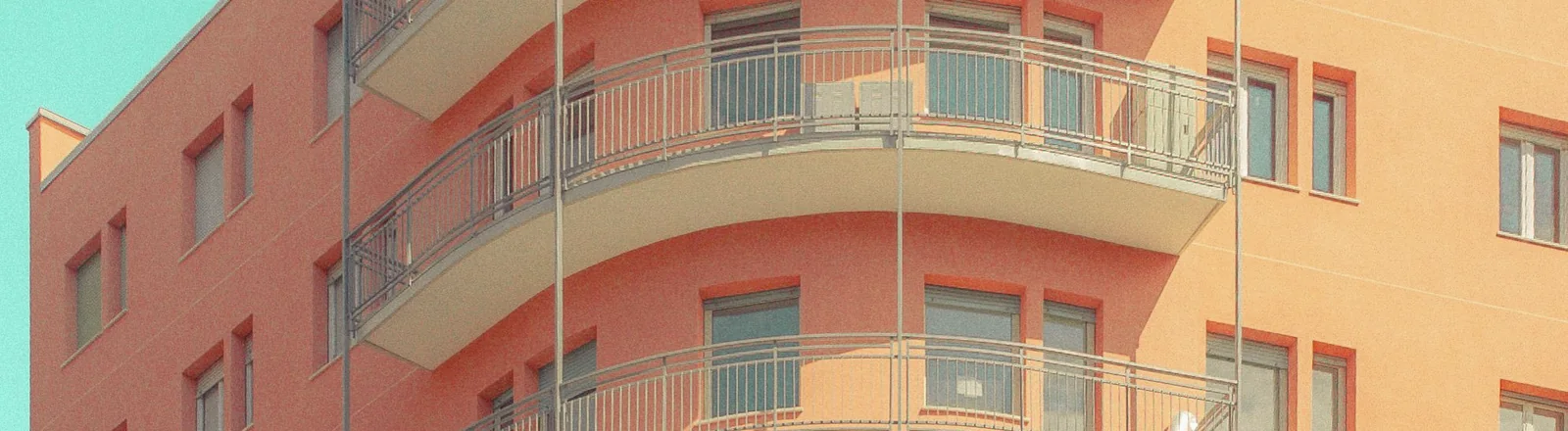Helles Mehrparteienhaus mit mehreren Balkonen