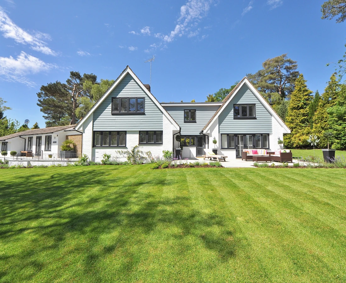 Helles Wohnhaus mit großem Garten unter blauem Himmel